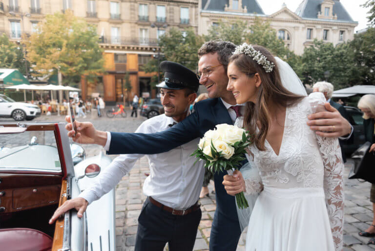 Deux mariés se prennent en photo devant l'église de Saint Germain des Prés à Paris