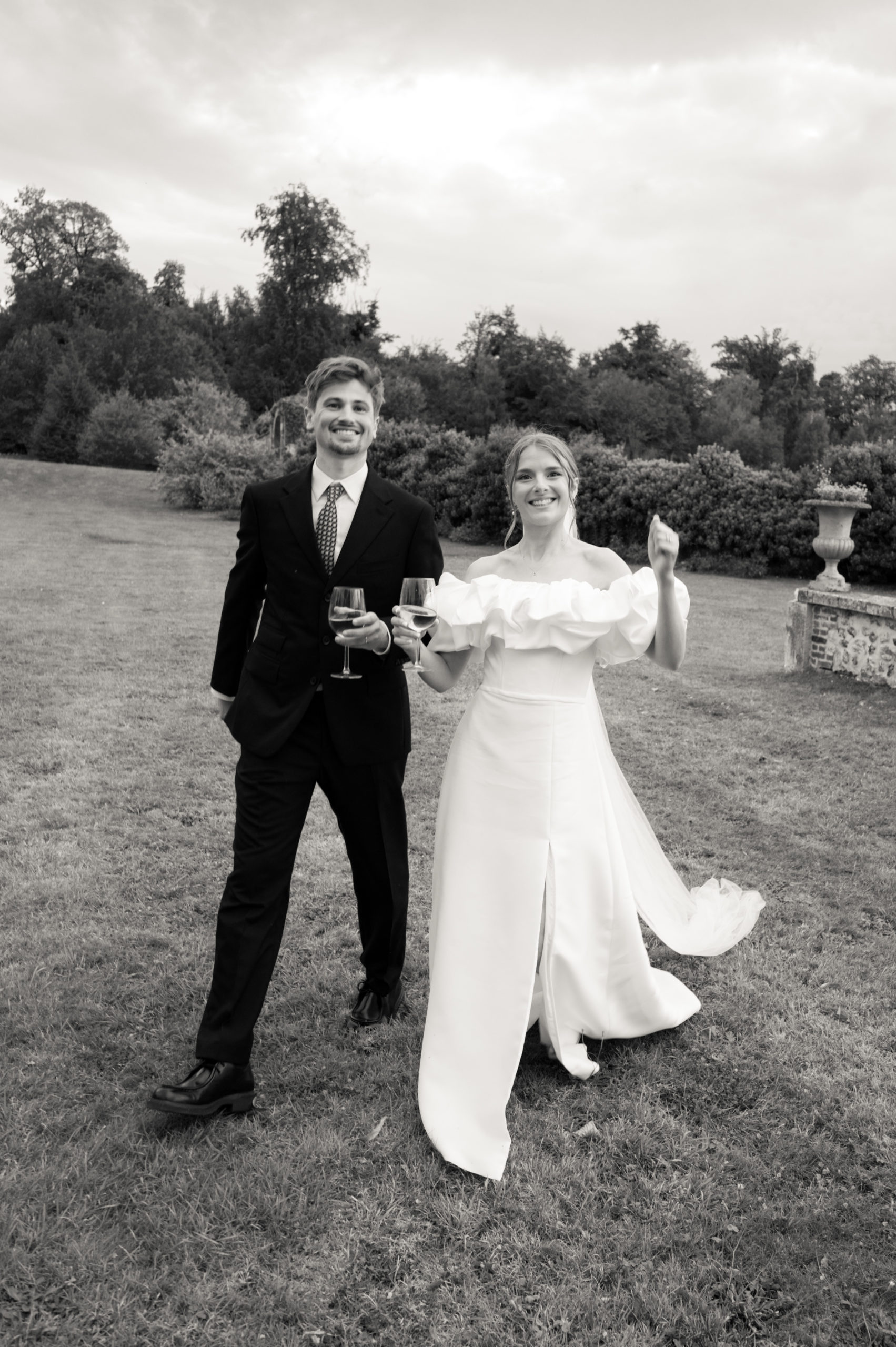photos en noir et blanc d'un couple de mariés marchant dans l'herbe au château d'argeronne en normandie