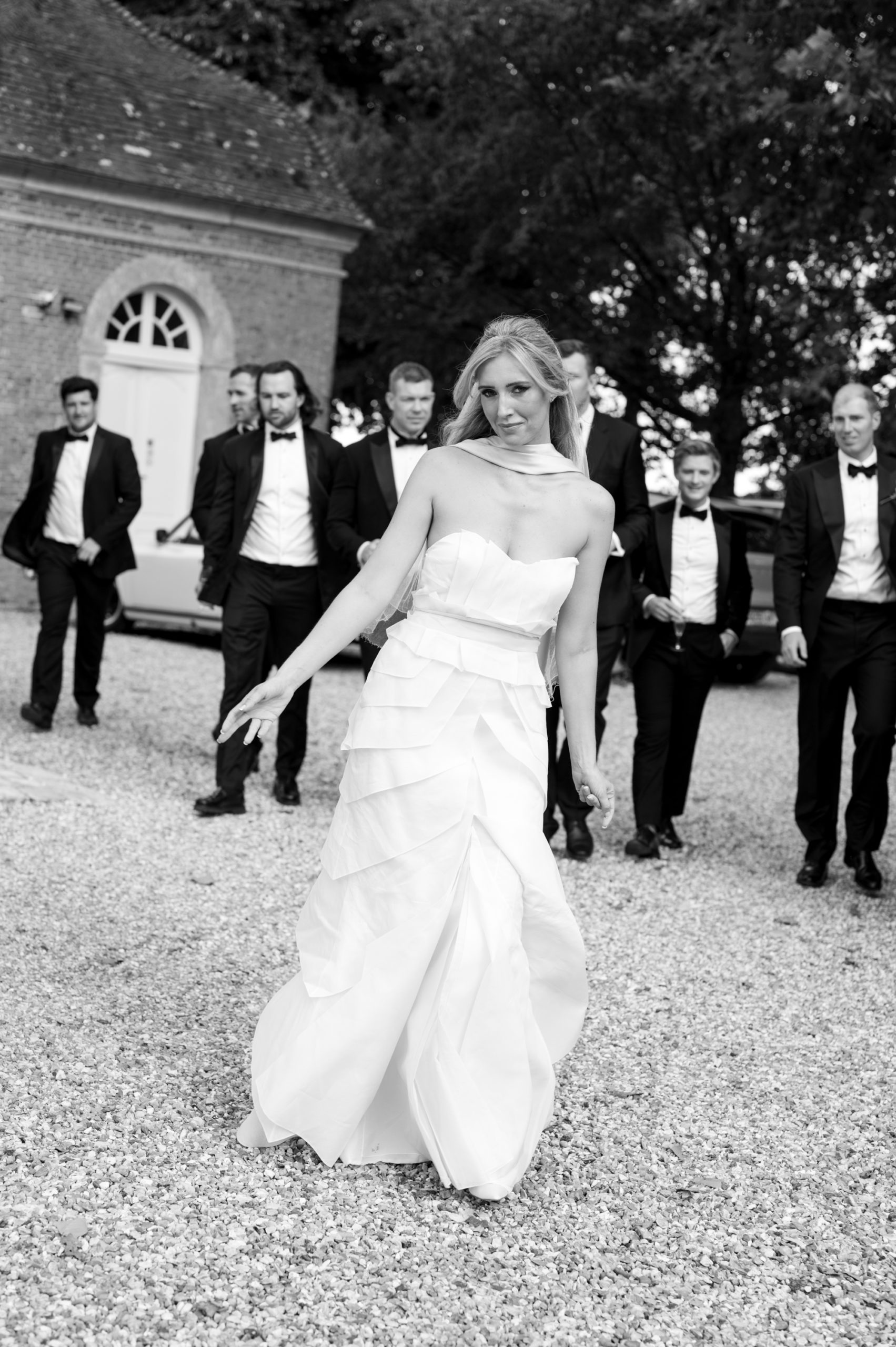 photos en noir et blanc d'un couple de mariés marchant dans l'herbe au château d'argeronne en normandie